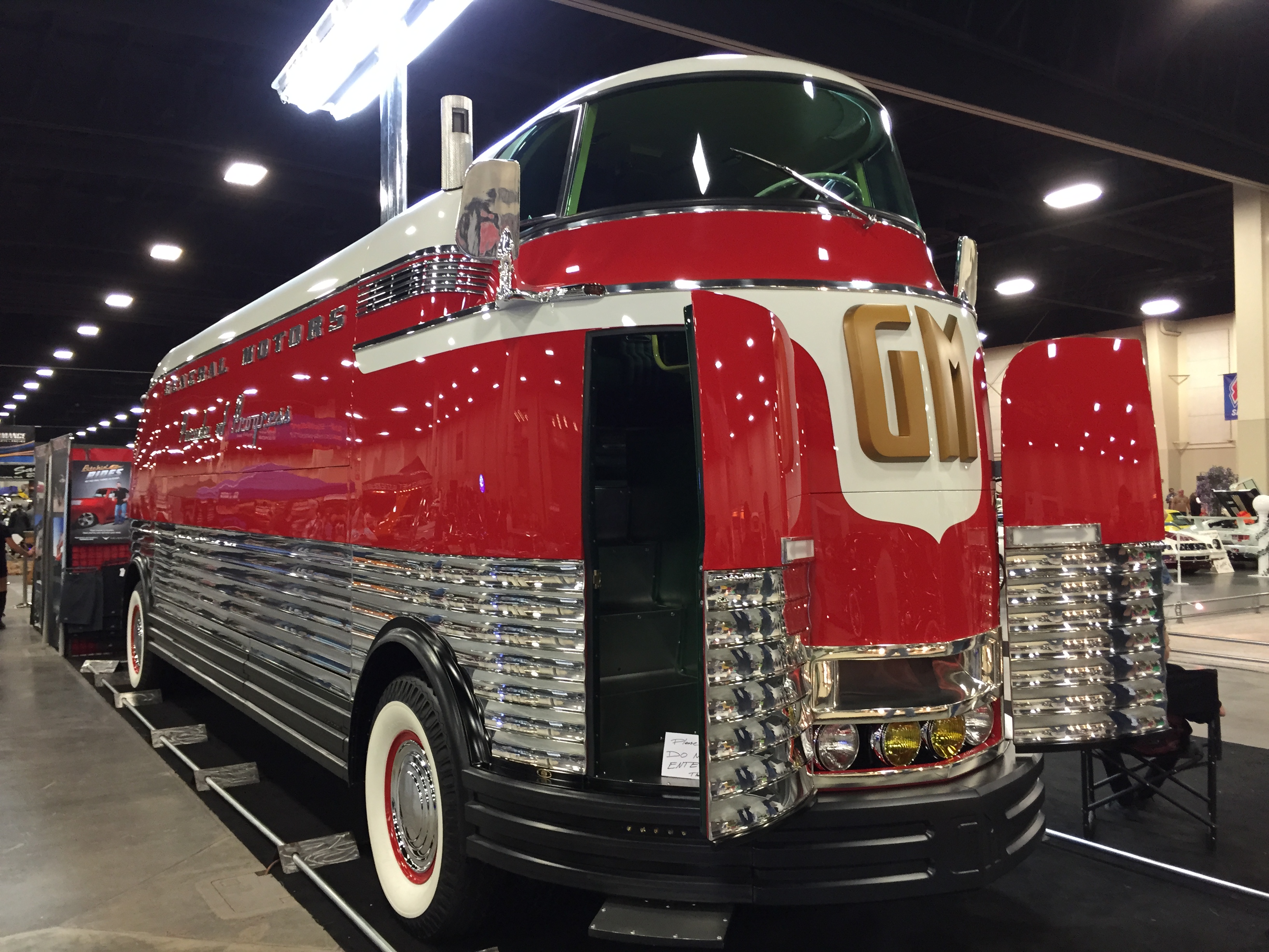 Rød og hvid GM Futurliner nummer 3 med åben udstillingsside, set skråt forfra.